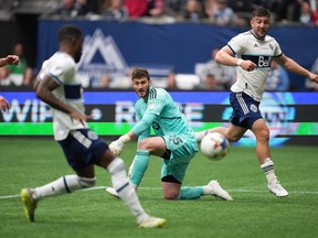 Toronto FC goalkeeper Alex Bono, centre, watches as Vancouver Whitecaps' Tosaint Ricketts, front left, scores after receiving a pass from Lucas Cavallini, back right, during the second half of an MLS soccer game in Vancouver, B.C., Sunday, May 8, 2022.