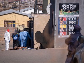 Gunmen kill 19 in 'random' bar shootings in South Africa 2 Members of the South African Police Service (SAPS) and forensic services inspect the scene of a shooting in Soweto, South Africa, July 10, 2022.