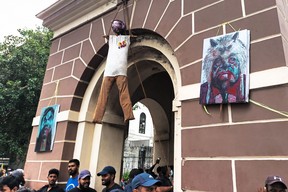 Sri Lankan protesters vow not to let up until the president and prime minister resign 3 Activists stand under the effigy of Sri Lankan President Gotabaya Rajapaksa, hanging from a clock tower near his official residence, in Colombo on July 10, 2022.