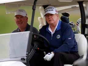 U.S. President Donald Trump drives a golf cart at the Trump National Golf Club in Sterling, Va.,  Nov. 22, 2020.