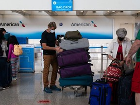 Passengers wearing protective masks check in and drop off luggage at the American Airlines Group Inc. ticket counter at Hartsfield-Jackson Atlanta International Airport in Atlanta, Georgia, U.S., on Wednesday, April 7, 2021. U.S. airlines are bringing back more pilots as they prepare for an expected travel rebound. Photographer: Elijah Nouvelage/Bloomberg
