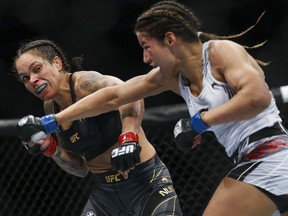 FILE - Julianna Pena, right, throws a right to Amanda Nunes during a women's bantamweight mixed martial arts title bout at UFC 269, Saturday, Dec. 11, 2021, in Las Vegas. Peña stunned pretty much everyone but herself when she took the bantamweight title from two-division champion Amanda Nunes in one of the biggest upsets in UFC history.