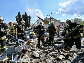 Firefighters take rubbles out of a damaged building following a Russian airstrike in the city of Vinnytsia, west-central Ukraine, on July 14, 2022.