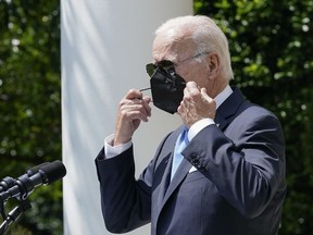 President Joe Biden removes his face mask as he arrives to speak in the Rose Garden of the White House in Washington, Wednesday, July 27, 2022.