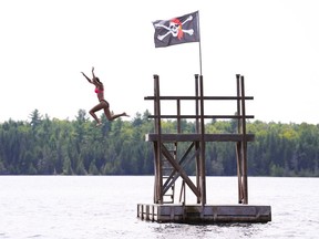 Anna Hirst jumps off a diving tower at Pickerel Bay Lodge and into White Lake in White Lake, Ont., on Tuesday, July 19, 2022. Environment Canada has issued heat warnings for most of Ontario.