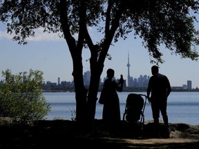 A family take pictures in the shade on a hot day in Toronto on Thursday, June 23, 2022.