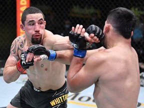 In this handout photo, (L-R) Robert Whittaker of Australia punches Kelvin Gastelum in a middleweight fight during the UFC Fight Night event at UFC APEX on April 17, 2021 in Las Vegas, Nevada.