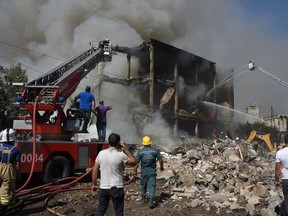 Rescue workera operate on the site of a retail market in the Armenian capital Yerevan on Sunday, Aug. 14, 2022, after an explosion sparked a fire, killing one person and injuring 51, according to the emergency situations ministry.