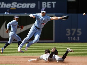 Whit Merrifield of the Blue Jays misses the catch as Tyler Freeman of the Cleveland Guardians steals second base in the fourth inning at Rogers Centre on Sunday, Aug. 14, 2022.