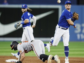 Ryan McKenna #26 of the Baltimore Orioles is forced out at second as Matt Chapman #26 of the Toronto Blue Jays unsuccessfully tries to throw out Cedric Mullins #31 at first in the ninth inning of their MLB game at Rogers Centre on August 16, 2022 in Toronto, Canada.