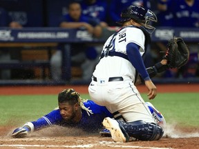 Raimel Tapia of the Toronto Blue Jays slides into home ahead of the tag by Christian Bethancourt  of the Tampa Bay Rays in the ninth inning during a game  at Tropicana Field on August 02, 2022 in St Petersburg, Florida.