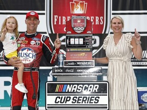 Kevin Harvick, driver of the #4 Busch Light Apple #BuschelOfBusch Ford, celebrates with his wife, DeLana Harvick and daughter, Piper in victory lane after winning the NASCAR Cup Series FireKeepers Casino 400 at Michigan International Speedway on August 7, 2022 in Brooklyn, Michigan.