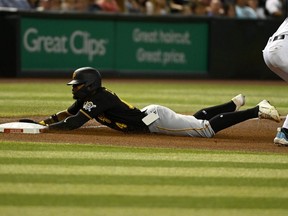 Rodolfo Castro of the Pittsburgh Pirates slides into third base as his cell phone falls out of his pocket during the fourth inning of a game against the Arizona Diamondbacks at Chase Field on August 09, 2022 in Phoenix, Arizona.