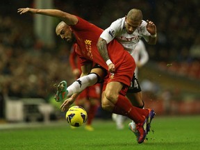 Jose Enrique of Liverpool tangles with Ashkan Dejagah of Fulham during the Barclays Premier League match between Liverpool and Fulham at Anfield on December 22, 2012 in Liverpool, England.