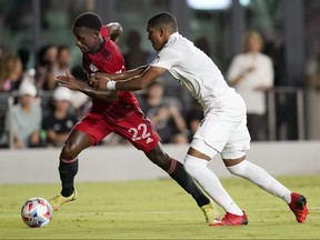 Toronto FC midfielder Richie Laryea (22) runs with the ball as Inter Miami defender Christian Makoun defends during the second half of an MLS soccer match, Wednesday, Oct. 20, 2021, in Fort Lauderdale, Fla.