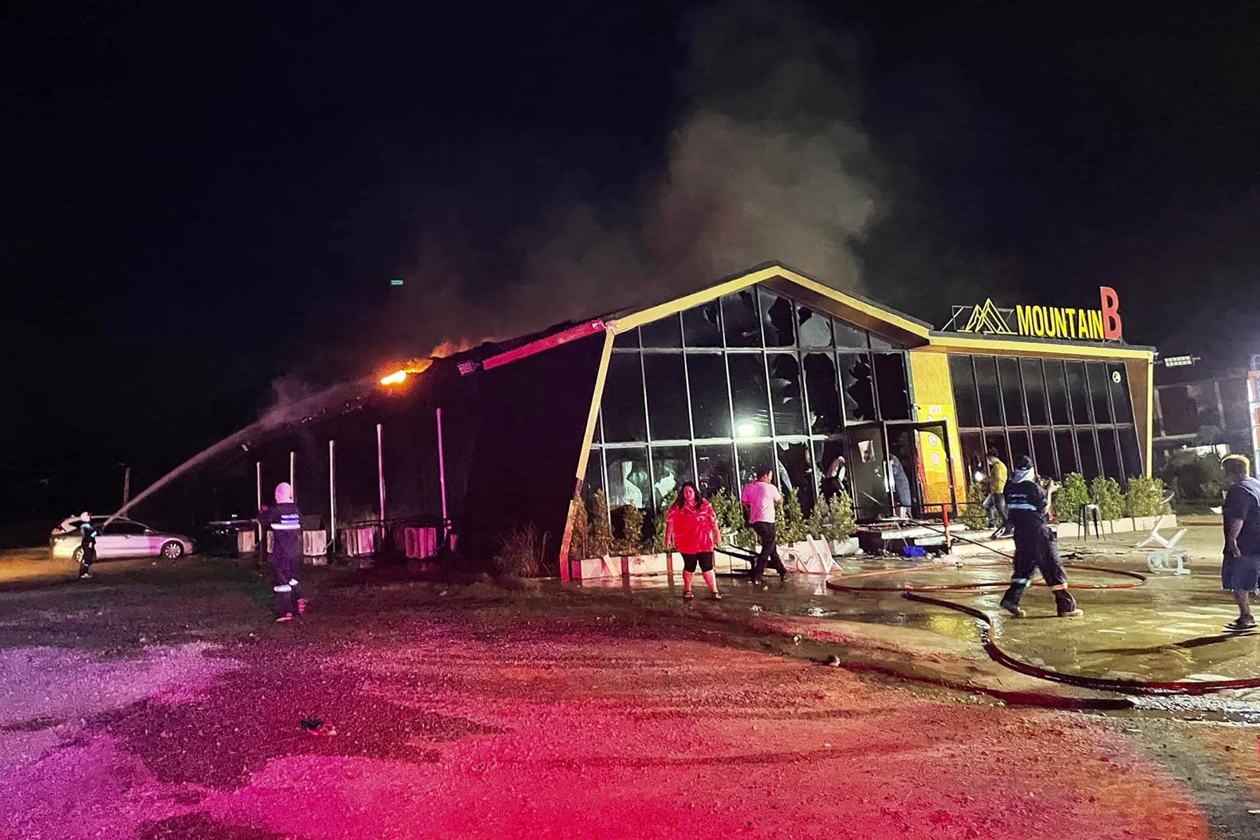 This handout photo taken and released on August 5, 2022 by the Sawang Rojanathammasathan Rescue Foundation shows firefighters working to contain a fire at the Mountain B nightclub in Sattahip district in Thailand’s Chonburi province. (Photo by HANDOUT/Sawang Rojanathammasathan Rescue/AFP via Getty Images)