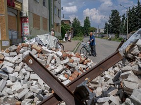 Ein Anwohner hält sein Fahrrad am 4. August 2022 inmitten der russischen Invasion in der Ukraine in Bakhmut, Ostukraine.  - Sie sehen unpassend aus, aber sie sind überall in der umkämpften östlichen Donbass-Region der Ukraine - ältere Radfahrer, die auf ramponierten Laufrädern hin und her rollen und sich nicht von dem Chaos um sie herum aus der Ruhe bringen lassen.  (Foto von Bulent KILIC/AFP) (Foto von BULENT KILIC/AFP via Getty Images)