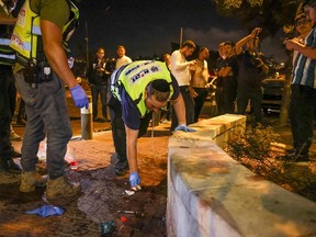 Zaka volunteers, an Ultra-Orthodox Jewish emergency response team, clean up blood stains after an attack outside Jerusalem's Old City, Aug. 14, 2022.