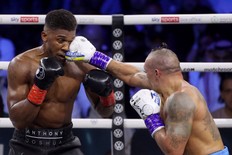 Ukraine's Oleksandr Usyk (R) and Britain's Anthony Joshua (L) compete during the heavyweight boxing rematch for the WBA, WBO, IBO and IBF titles, at the King Abdullah Sports City Arena in the Saudi Red Sea city of Jeddah, on August 20, 2022.