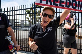 Demonstrators cheer as cars driving by show support by honking at them during a protest against the recent actions of the FBI at their Boston headquarters in Chelsea, Mass., on Aug. 21, 2022.