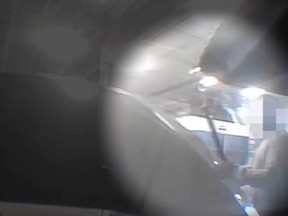Hidden camera footage of an auto body shop employee deliberately damaging the vehicle by striking the car's open hood on the passenger's side.