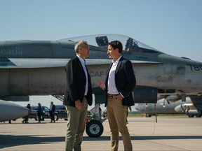 Prime Minister Justin Trudeau speaks with NATO Secretary General Jens Stoltenberg near a Canadian Forces CF-18 Hornet fighter aircraft during their visit to CFB Cold Lake in Cold Lake, Alta., Aug. 26, 2022.