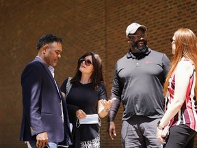 From left, former NFL player Ken Jenkins and his wife Amy Lewis, along with former NFL player Clarence Vaughn III and his wife Brooke Vaughn, meet before delivering tens of thousands of petitions demanding equal treatment for everyone involved in the settlement of concussion claims against the NFL, to the federal courthouse in Philadelphia, Friday, May 14, 2021.
