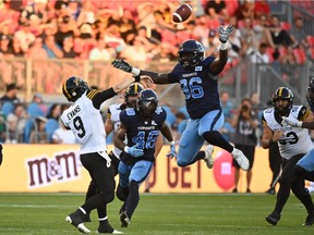 Hamilton Tiger-Cats quarterback Dane Evans gets a pass away over Toronto Argonauts lineman Dan Acheampong  during first-half action in Toronto on Saturday, August 6, 2022. The Argos won 34-20.