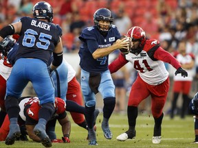 Toronto Argonauts quarterback McLeod Bethel-Thompson tries to evade a tackle by Calgary Stampeders defensive lineman Mike Rose  during first half CFL football action in Toronto on Saturday, August 20, 2022.