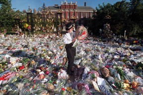 Eine britische Polizistin sammelt einige der Blumensträuße ein, die vor dem Kensington Palace in London, dem ehemaligen Wohnsitz der Prinzessin von Wales, zurückgelassen wurden.