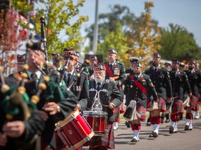 The Essex and Kent Scottish Pipe Band march during a commemoration marking the 80th anniversary of the Dieppe Raid, in Dieppe Gardens in Windsor, Ont., on Friday, Aug. 19, 2022.