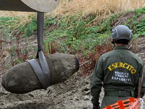 Members of the Italian army remove a Second World War bomb that was discovered in the dried-up River Po which has been suffering from the worst drought in 70 years, in Borgo Virgilio, Italy, Aug. 7, 2022.