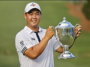 Joohyung Kim holds his trophy after winning the Wyndham Championship golf tournament Aug 7, 2022.