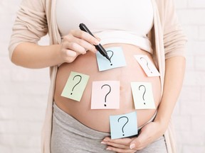 Pregnant woman embracing her belly with question mark on it