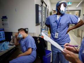 A nurse holds her head as nurses care for patients suffering from coronavirus disease (COVID-19) at Humber River Hospital's Intensive Care Unit, in Toronto, Ontario, Canada, on April 28, 2021.