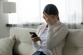 Woman looking at dating app, feeling hopeless about options. GETTY IMAGES