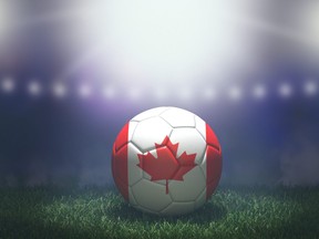 Soccer ball in flag colors on a bright blurred stadium background. Canada.