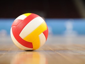A volleyball on a wooden gym floor