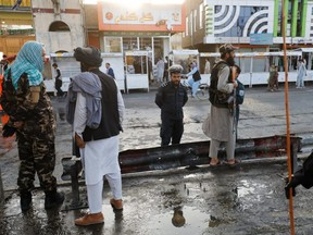Taliban fighters stand guard at the site of a blast in Kabul, Afghanistan, Aug. 6, 2022.