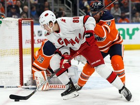 Edmonton Oilers' Kris Russell (4) battles Carolina Hurricanes' Martin Necas (88) at Rogers Place in Edmonton, on Tuesday, Dec. 10, 2019.