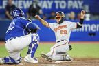 Ramon Urias of the Baltimore Orioles slides home safely to score on a Ryan McKenna single against the Blue Jays in the sixth inning on Tuesday night at the Rogers Centre.