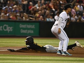 Rodolfo Castro of the Pittsburgh Pirates slides into third base as Josh Rojas of the Arizona Diamondbacks waits on a throw at Chase Field on August 9, 2022 in Phoenix.