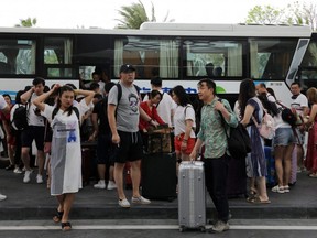 People get off a coach at an entrance of Atlantis Sanya resort in Sanya, Hainan province, China, Nov. 25, 2020.
