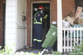 Toronto Fire Department Investigator Captain Kevin Hooke (red helmet) and Ontario Fire Marshal Investigator Jim Kettles enter a home where a fatal two-alarm fire occurred on the Riverdale Ave. JACK BOLAND/TORONTO SUN