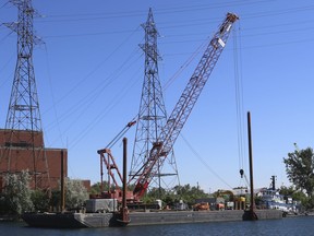 A barge with a crane on it being pushed by a tug boat clipped some overhead power lines in front of the defunct Hearn Power station on Thursday, August 11, 2022.