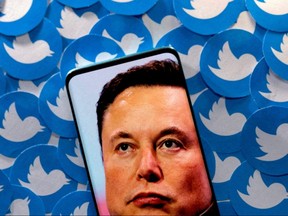 An image of Elon Musk can be seen on a smartphone placed over the Twitter logo printed in this pictorial illustration.