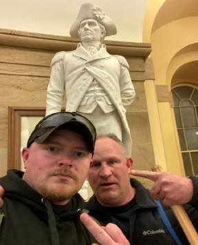 Jacob Fracker and Thomas Robertson, off-duty Rocky Mount, Virginia police officers at the time, gesture in a selfie during the storming of the U.S. Capitol in Washington, D.C., Jan. 6, 2021.