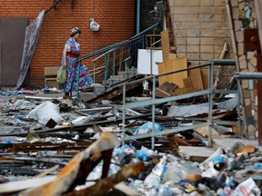 A woman walks outside an apartment building damaged in the course of Ukraine-Russia conflict in the southern port city of Mariupol, Ukraine August 21, 2022.