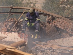 A Ukrainian firefighter rests in a factory destroyed by a Russian strike in the city of Slovyansk, in Donetsk region, Ukraine, August 27, 2022.