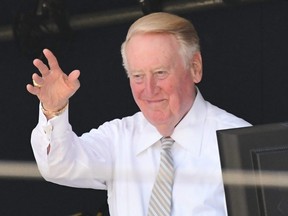 Long-time Dodgers broadcaster Vin Scully acknowledges the umpired crew before the start of the game against the Cubs at Dodger Stadium in Los Angeles, Aug. 28, 2016.
